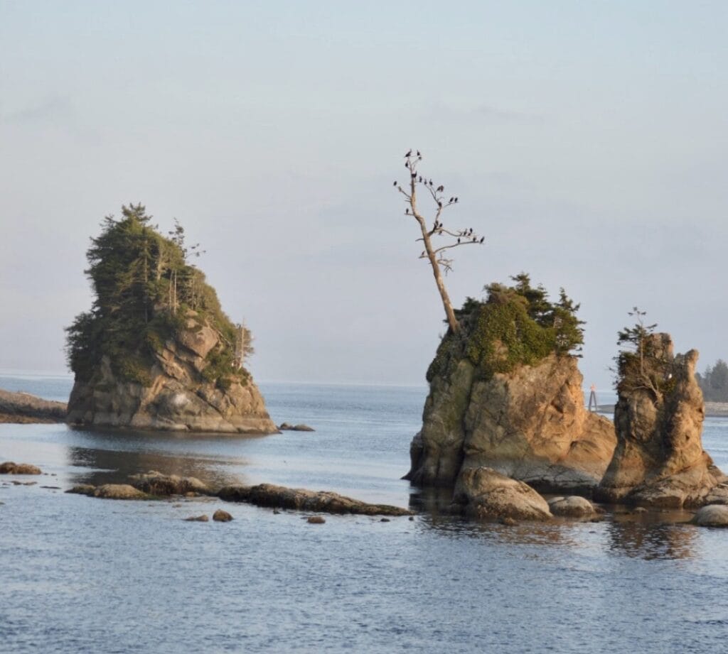 The Three Graces stand among peaceful water and late afternoon sunlight.