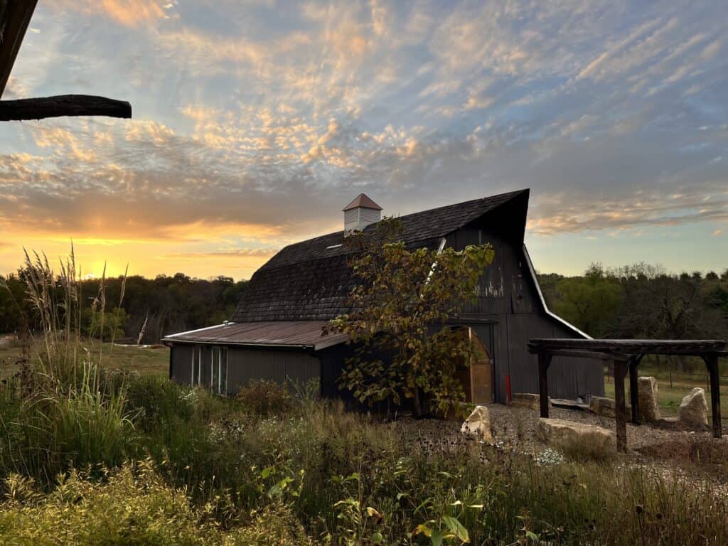 The wedding barn at Circle S Ranch with the sun rising behind.