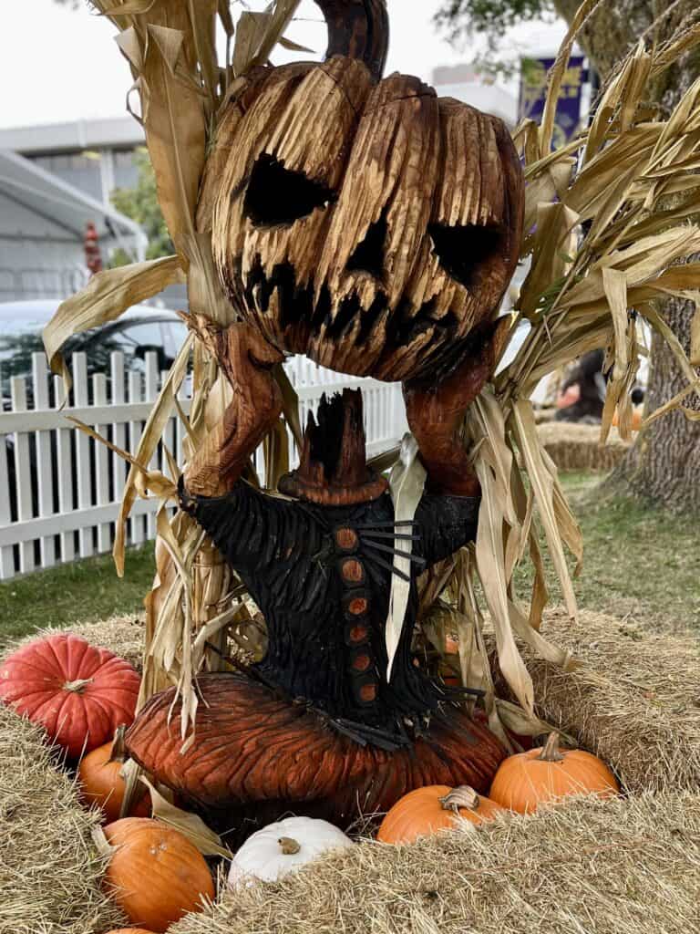 Creepy wood carved headless pumpkin decoration at Halloweentown.