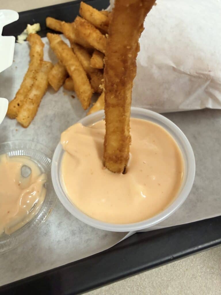 A French fry dipping in fry sauce