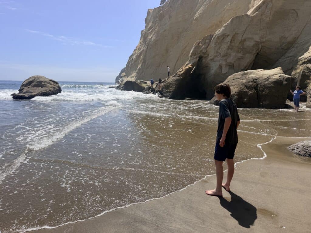 Our son stands in the surf at Pacific City beach.