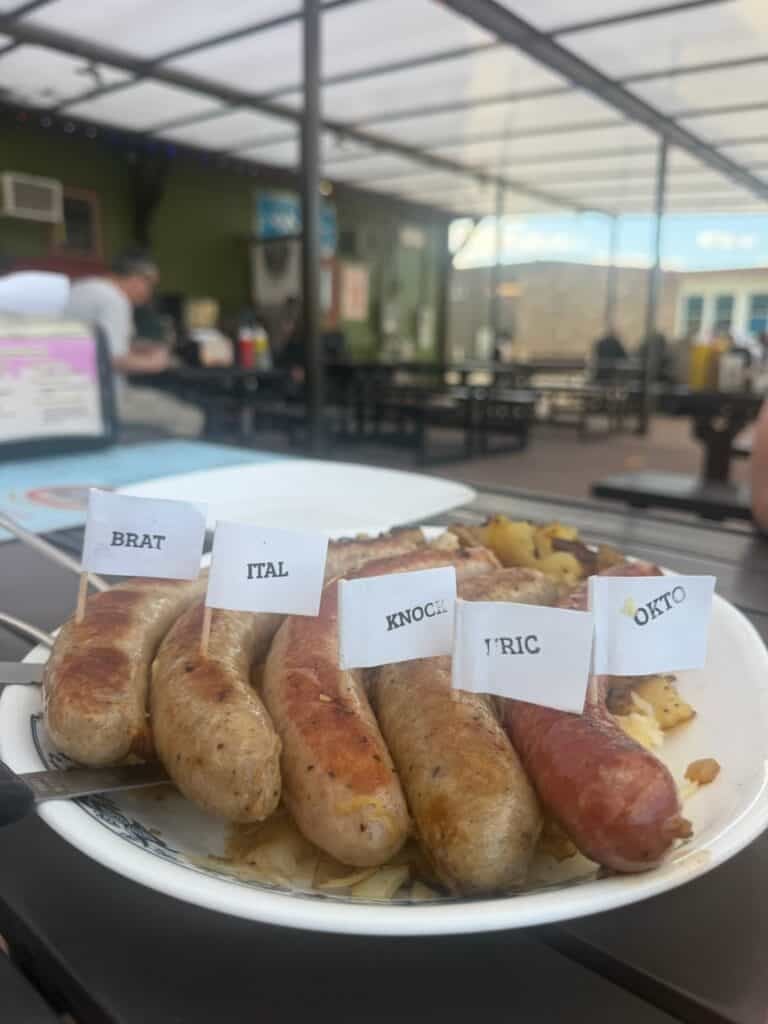 five different sausage types on a plate with German potato salad at the Mt Angel Sausage Company.