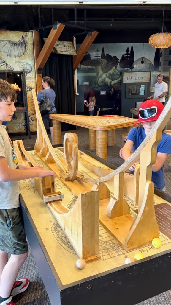 Our boys experiment with balls on a roller coaster at the Da Vinci exhibit.